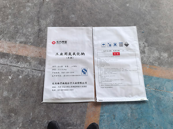 Close up view of shipping batch tag printed with caustic soda flakes price lot identification numbers