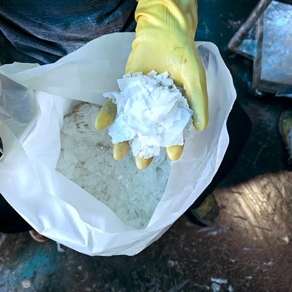 Pure white sodium hydroxide lye flakes close up view