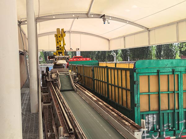 Heavy duty crane hoisting pallet of caustic soda micropearls onto high sided transport truck