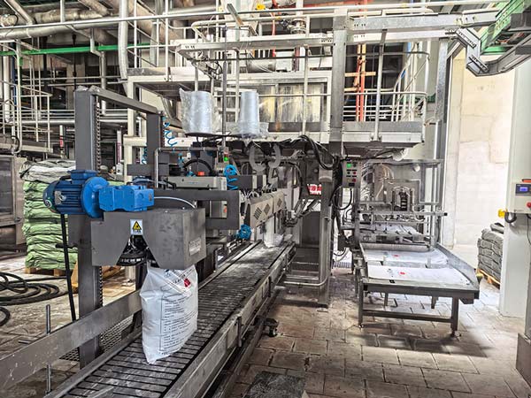 Heavy duty industrial sewing mechanism stitching the top closure of 25kg sodium hydroxide bag