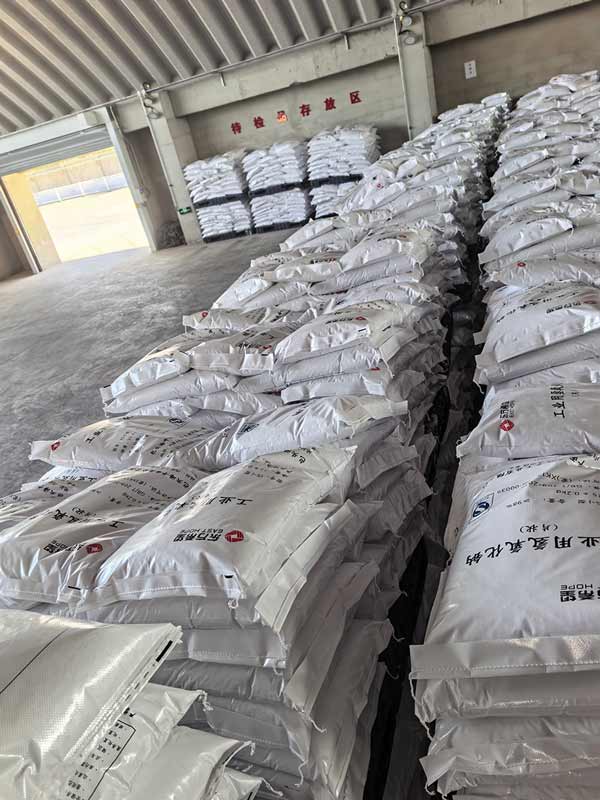 Customer collecting 25kg caustic soda flake bags at local chemical supply store counter