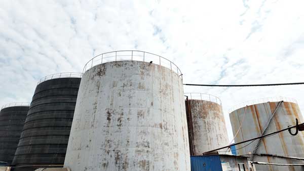 Large chemical storage tanks at a solid caustic soda manufacturing plant