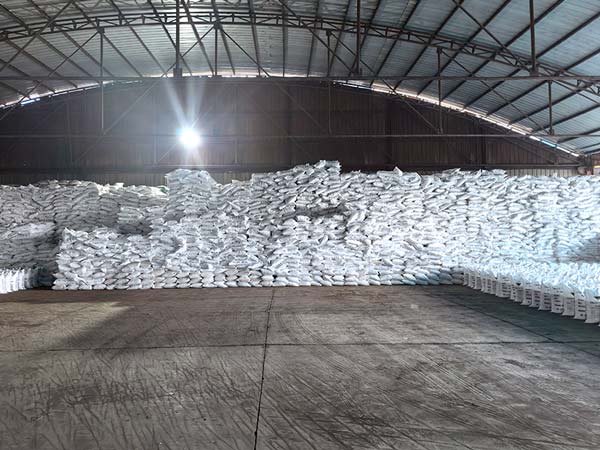 Pallet of caustic soda bags stored in dry industrial chemical warehouse
