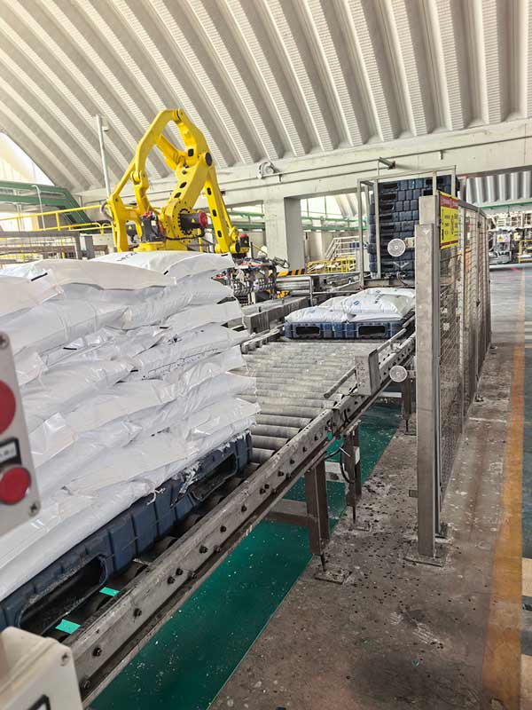 Hydraulic liftgate hoisting a stacked pallet of soda pearls up to the rear entrance of a box truck