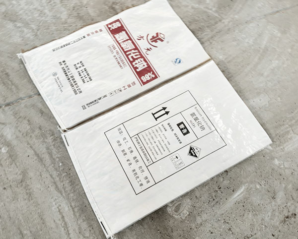 Macro close up of double stitched top seam on paper plastic laminated sodium hydroxide flakes package