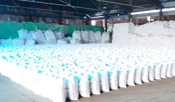 Interlocking cross pattern palletized structure holding twenty five kilogram sodium hydroxide flakes bags firm
