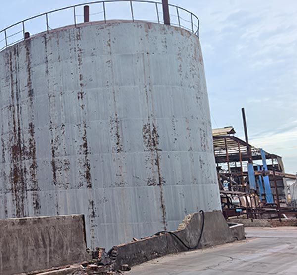 Exterior view of tall cylindrical chemical distillation columns dominating the skyline of lye flakes for soap making factory