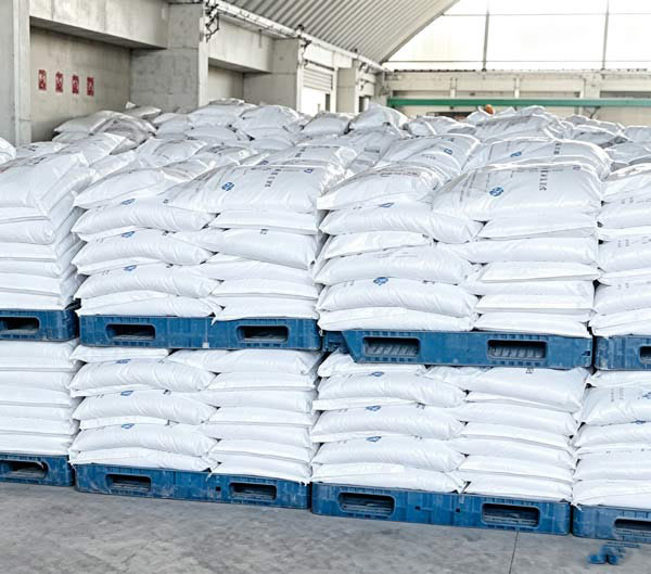 Compact four-bag square tier layout forming a uniform columnar stack of bagged NaOH flakes stock on composite skid