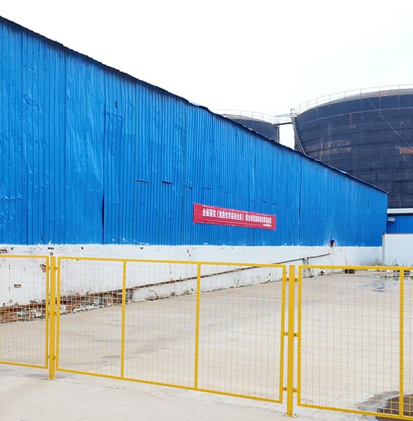 Exterior view of industrial chemical warehouse facility for caustic soda for sale featuring long blue corrugated steel siding