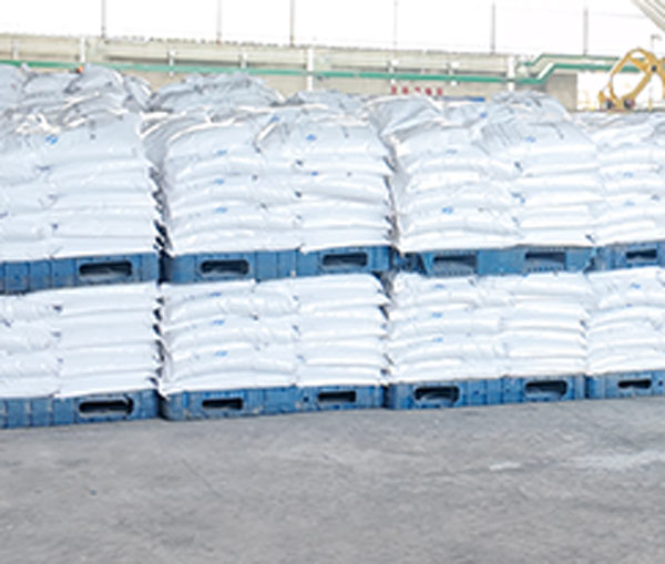Compact columnar stack layout of bagged 50kg caustic soda stock bound securely with heavy plastic banding