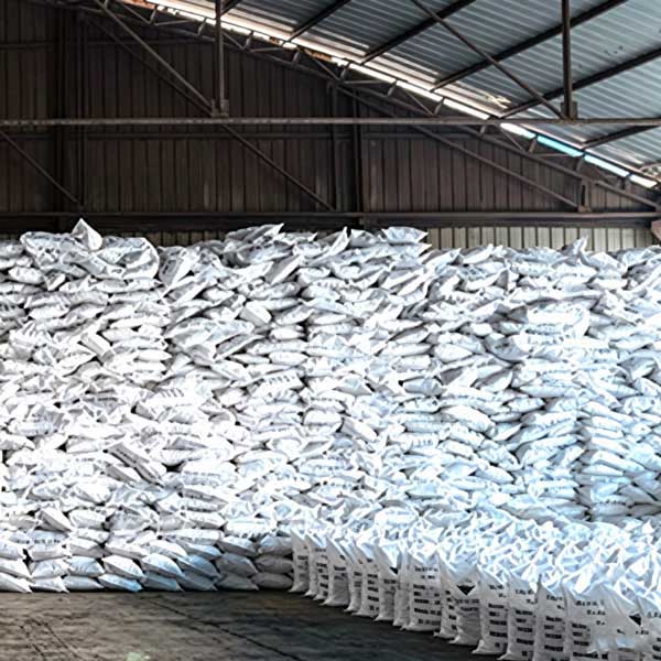 Compact four-block square tier layout forming a columnar stack of bagged caustic soda product stock on pallet