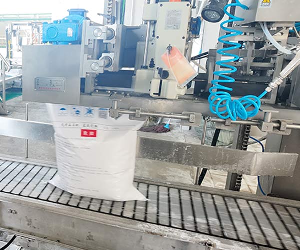 Continuous heat-embossing bag sewing conveyor belt transferring sealed caustic soda packages down production line