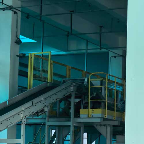 Industrial liquid red devil lye filling line conveyor system in a modern chemical packaging facility.
