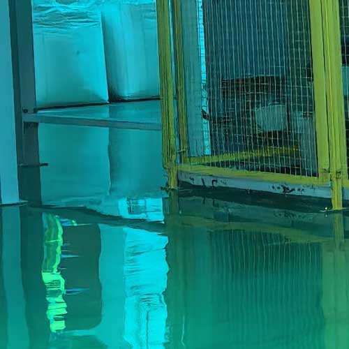 Chemical warehouse interior showing safety yellow wire mesh fencing and high-gloss reflective floor