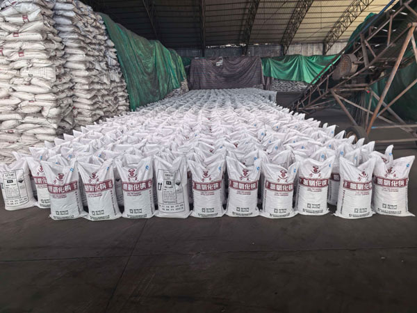 Wide perspective of bagged sodium hydroxide packages showcasing various industrial caustic soda types near conveyor