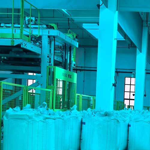 High ceiling industrial warehouse with bulk chemical bags used in formilating products with sodium hydroxide.