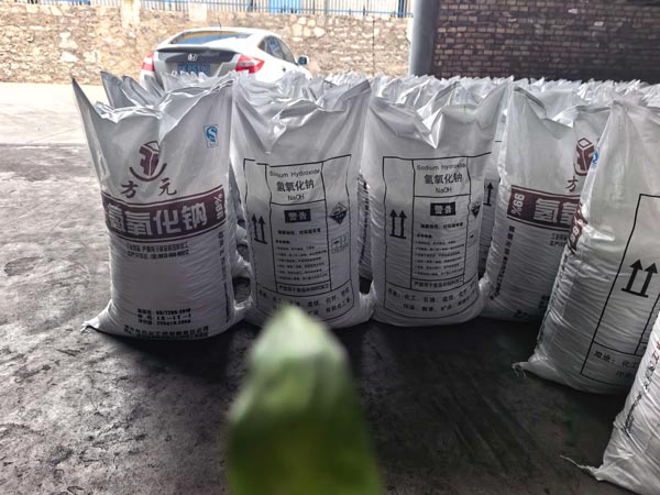 Staged chemical raw material sacks stored near loading bay for solution preparation and pumping caustic soda