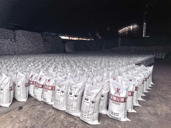 Dense matrix layout of upright white woven bags containing high-grade pure caustic soda in factory staging area