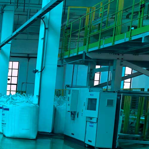 Modern chemical plant facility processing bulk bags of sodium hydroxide chemical on an automated production line