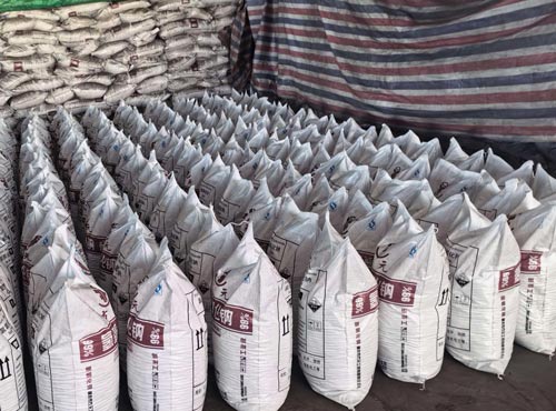 Massive inventory of 25kg bags containing high purity industrial grade caustic soda flakes for large scale manufacturing.