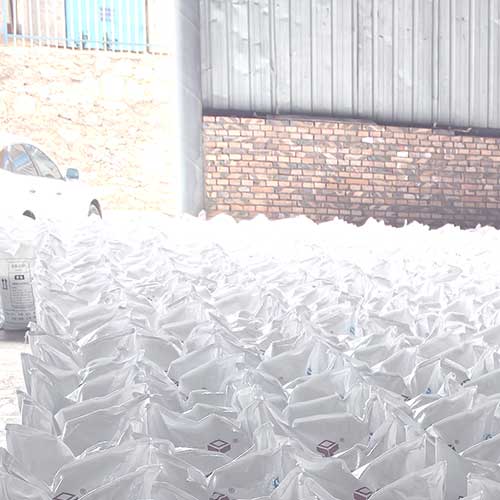 Stacks of sodium hydroxide (caustic soda) flakes in bags from a reliable sodium hydroxide supplier, neatly arranged in a warehouse ready for shipment