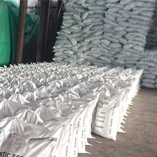 Industrial chemical supply of Na hydroxide flakes, stacked neatly on a clean warehouse floor for fast dispatch.