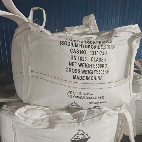 Warehouse floor staged with UN-certified 1-ton bags of caustic soda pearls for large-volume industrial buyers.