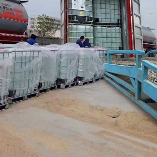 Workers managing the loading of liquid caustic soda 32% IBC totes for secure international transportation and supply chain delivery
