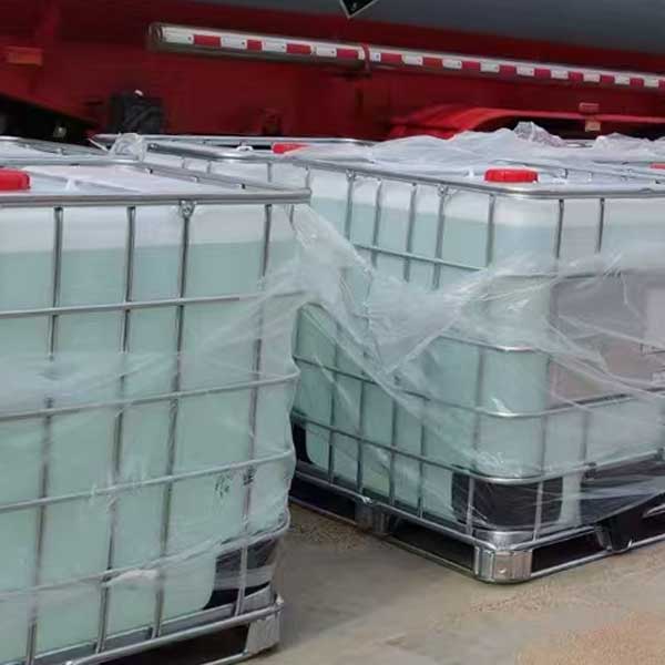 Liquid NaOH stored in white IBC totes with metal protective frames, red caps, and protective plastic wrap.