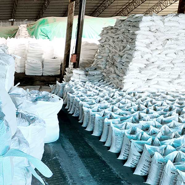 Industrial chemical factory warehouse filled with extensive rows of high-purity sodium hydroxide 99 bags ready for bulk distribution.