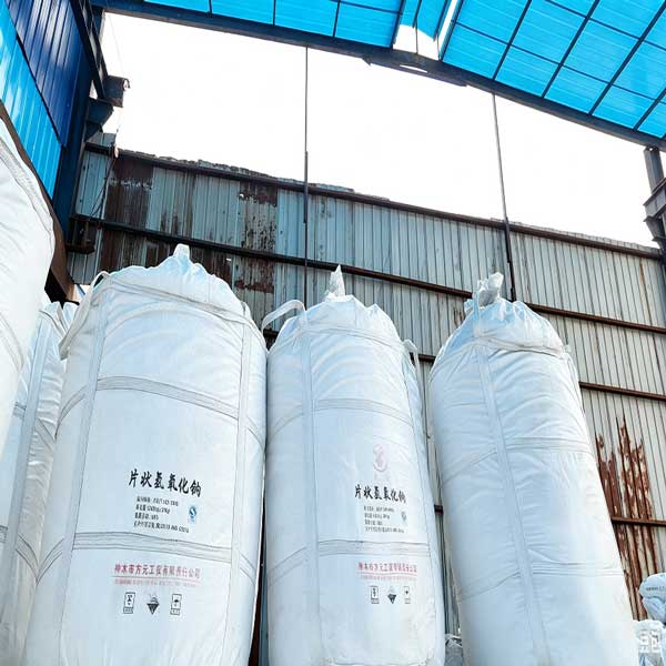 Large-scale storage of industrial caustic soda big bags ready for ocean transport and supply chain delivery by a sodium hydroxide supplier.