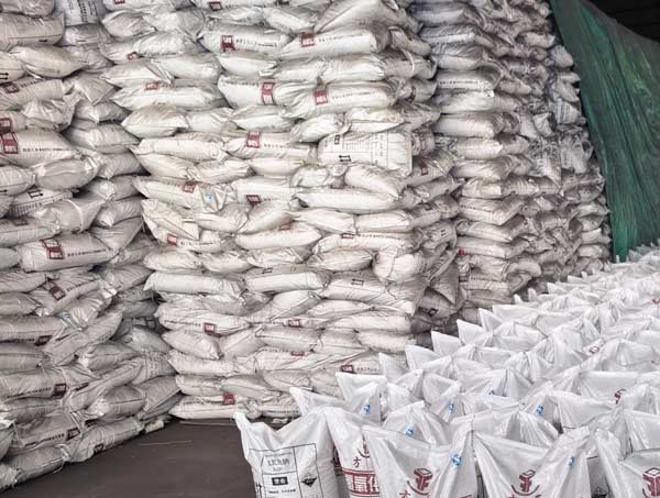 factory warehouse floor filled with neatly arranged caustic soda bag rows