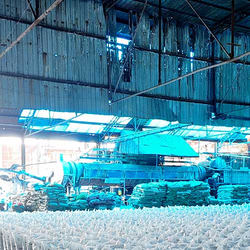 Large-capacity chemical storage facility featuring heavy machinery and stacked bagged products from trusted sodium hydroxide bulk suppliers.