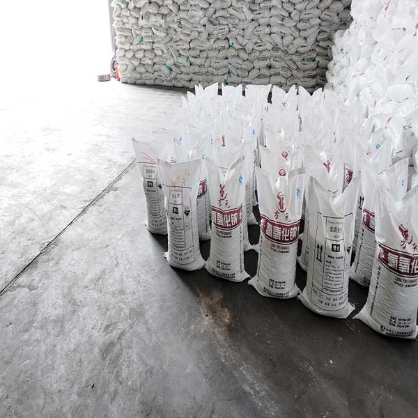High-purity 25kg sodium hydroxide bags prepared for international ocean shipping inside a facility owned by sodium hydroxide manufacturers.