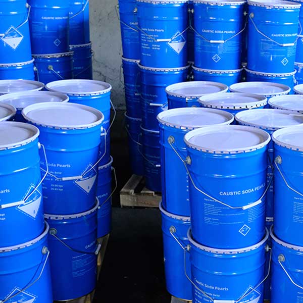 Massive warehouse inventory of stacked blue steel drums containing high-purity caustic soda beads.