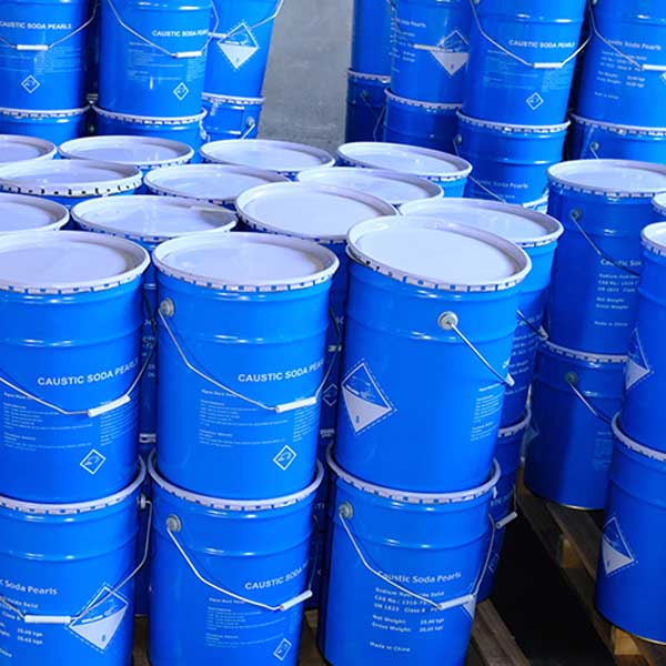 Scalable factory inventory of blue metal drums ready for ocean freight shipping and industrial supply of caustic soda beads.