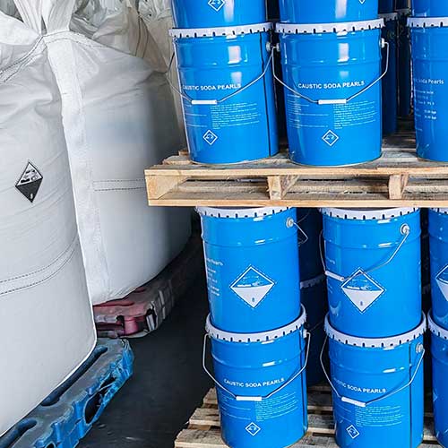 UN-certified Class 8 blue metal pails stacked on wooden pallets for quick regional dispatch of caustic soda beads near me.