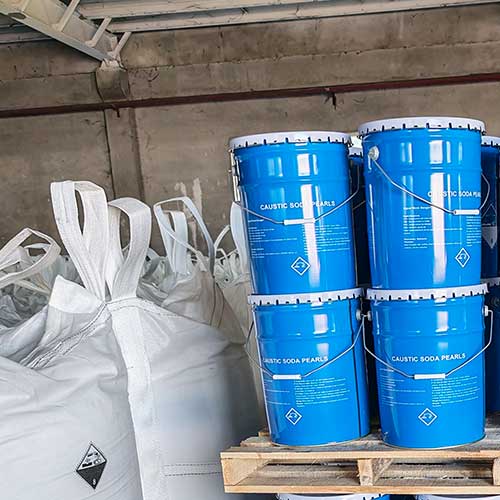 Moisture-resistant blue metal drums stored in a regional warehouse for fast fulfillment of caustic soda beads near me.