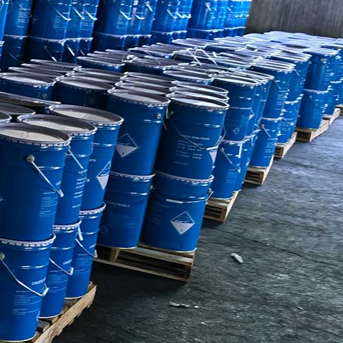 Sturdy blue metal pails with handles prepared for international shipping by global caustic soda beads suppliers.
