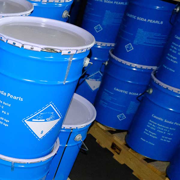 Palletized chemical warehouse storage of 25kg blue drums filled with spherical caustic soda prills.