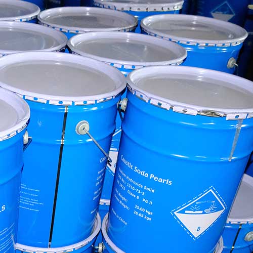 Heavy-duty UN-certified blue metal drums engineered for long-distance maritime transport of caustic soda prills.