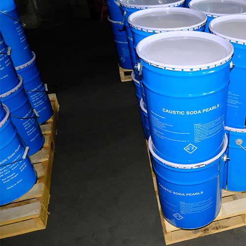 UN-certified Class 8 blue steel drums stacked on wooden pallets for economical caustic soda prills price sourcing.