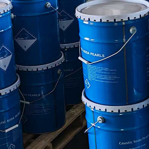 Securely stacked blue steel drums ready for international export and bulk delivery of pels caustic soda beads.