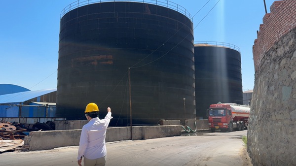 Industrial facility representative highlighting raw material holding tanks to buyers planning to buy caustic directly.